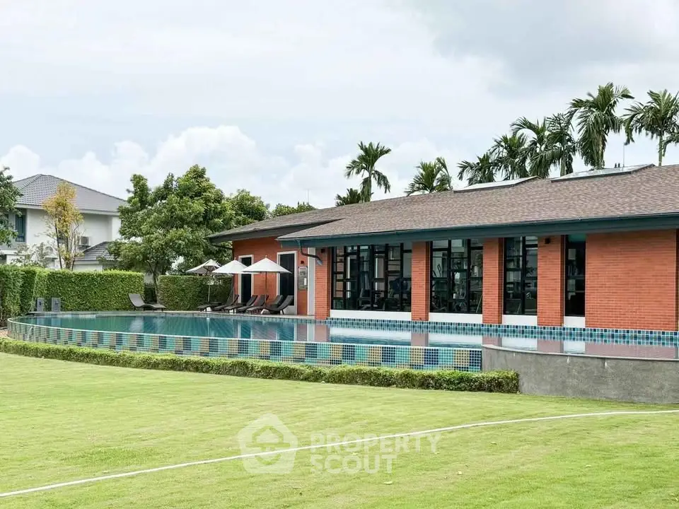 Luxurious residential pool area with modern architecture and lush greenery, perfect for relaxation and leisure.