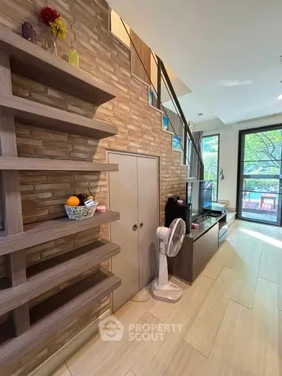 Modern living room with stylish shelving and large windows offering natural light and garden view.