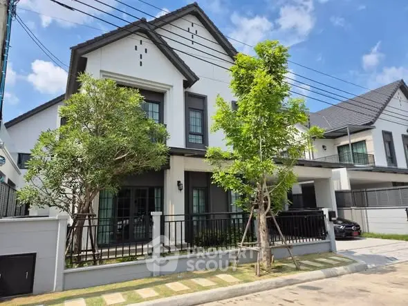 Modern two-story house with landscaped front yard and contemporary design.