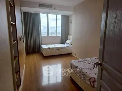 Spacious bedroom with twin beds and city view window