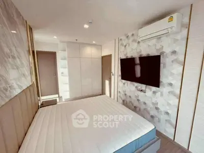 Modern bedroom with stylish decor and wall-mounted TV, featuring sleek storage solutions.