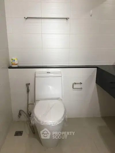 Modern bathroom with sleek design featuring a toilet and minimalistic decor.