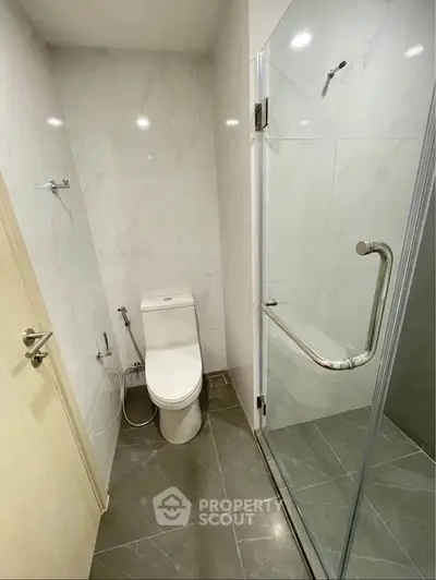 Modern bathroom with glass shower and sleek tile flooring