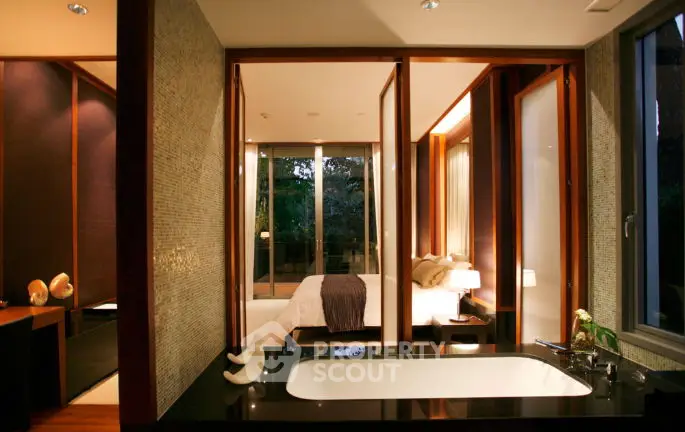 Luxurious modern bedroom with ensuite bathroom featuring a sleek bathtub and elegant decor.