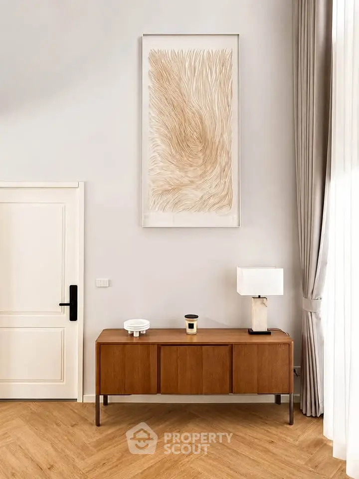 Elegant living room with modern decor, featuring a stylish sideboard and contemporary artwork.