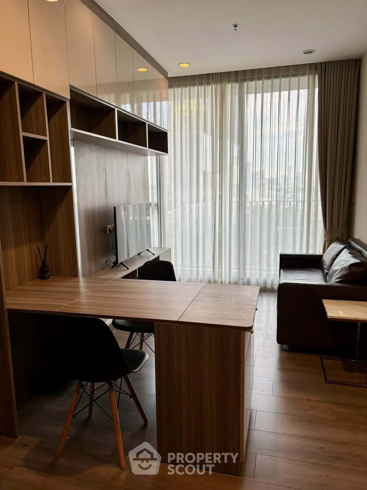 Modern living room with sleek furniture and large window, perfect for urban living.