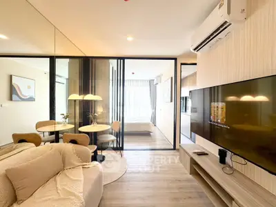 Modern open-plan living room with glass partition, cozy seating, and stylish decor in a contemporary apartment.