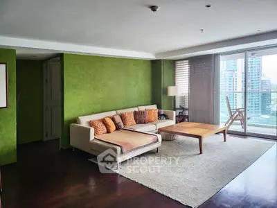 Spacious living room with green accent wall and city view balcony