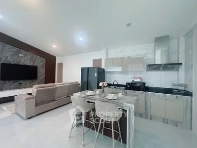 Modern open-layout kitchen and living room with sleek design and stylish furniture.