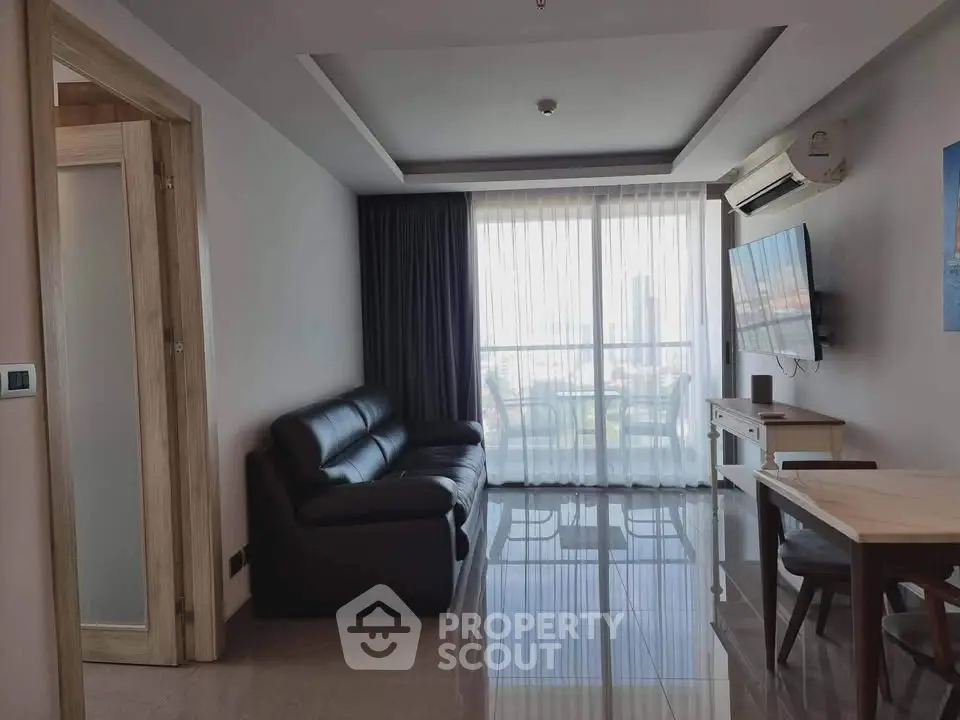 Modern living room with sleek furniture and large window offering city view.