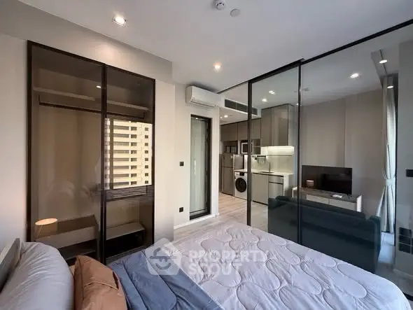 Modern studio apartment with glass partition and sleek kitchen appliances