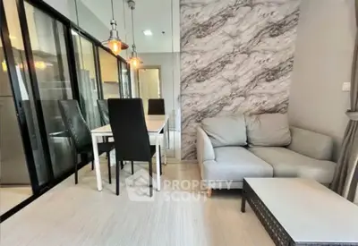 Modern living room with stylish decor and dining area, featuring a cozy sofa and elegant lighting.