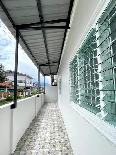 Charming exterior balcony with tiled flooring and modern window design, perfect for enjoying outdoor views.