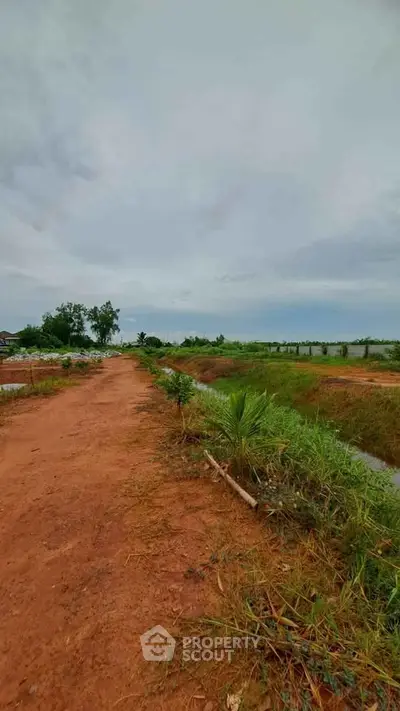 Expansive land plot with lush greenery and clear skies, ideal for development or agriculture.