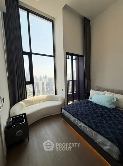 Luxurious bedroom with floor-to-ceiling windows offering stunning city views and elegant modern furnishings.