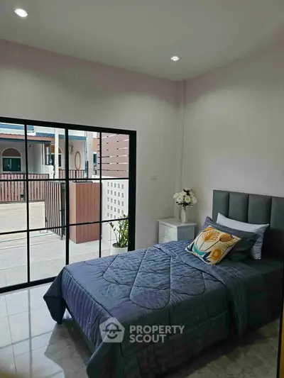Modern bedroom with single bed and large window overlooking balcony