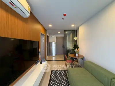 Modern living room with green sofa and open kitchen layout