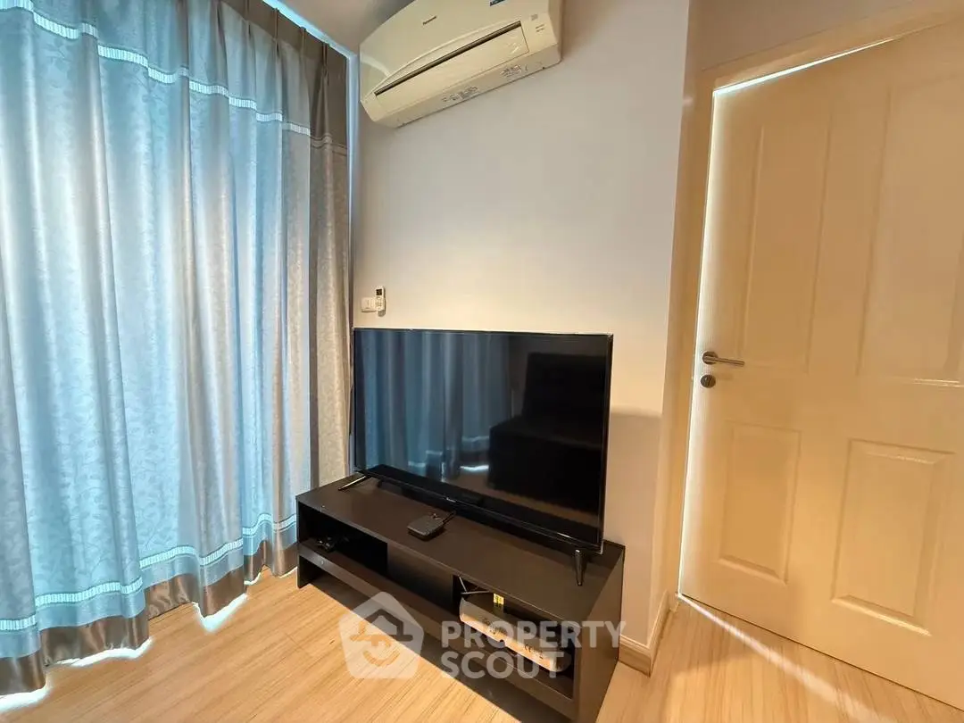 Modern living room with sleek TV setup and air conditioning, perfect for cozy entertainment.