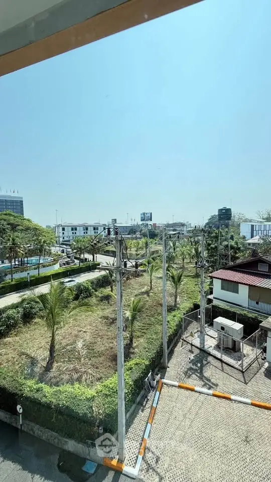 Scenic view from a high-rise building overlooking lush greenery and urban landscape.