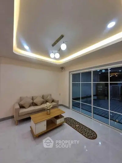 Modern living room with elegant lighting and sliding glass doors to patio.