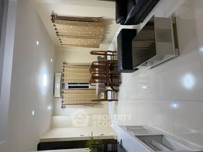 Spacious living room with elegant dining set and modern lighting.