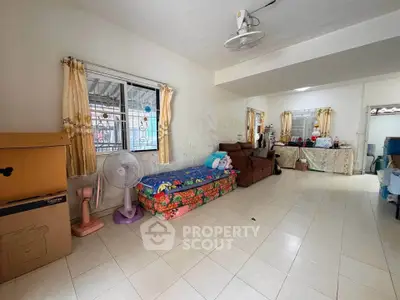 Spacious living room with tiled floor and cozy seating area, perfect for family gatherings.