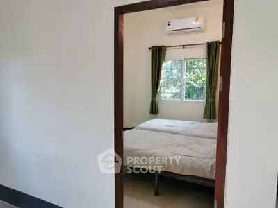 Cozy bedroom with air conditioning and natural light, perfect for relaxation.