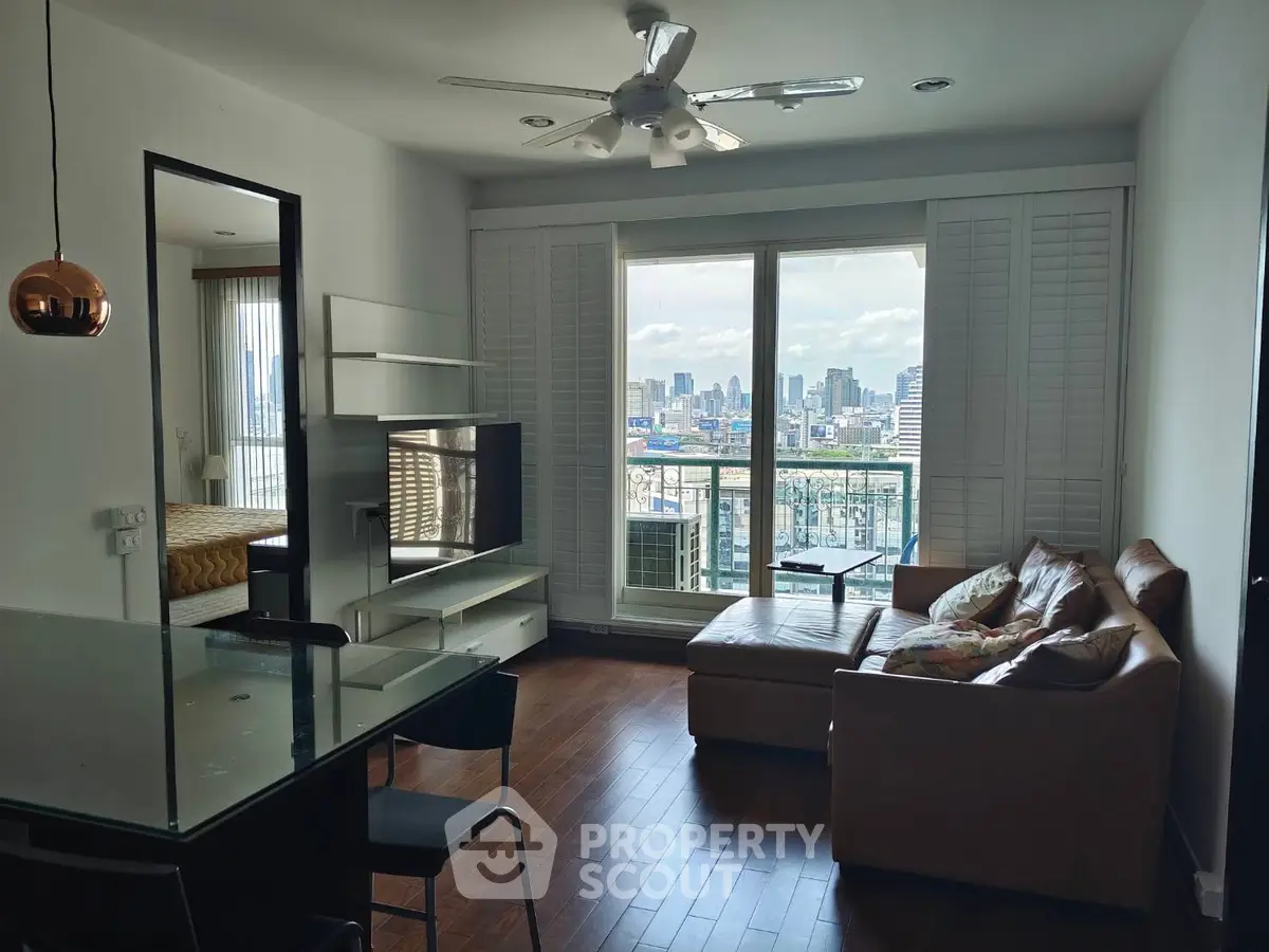 Modern living room with city view, featuring leather sofa and ceiling fan, perfect for urban living.
