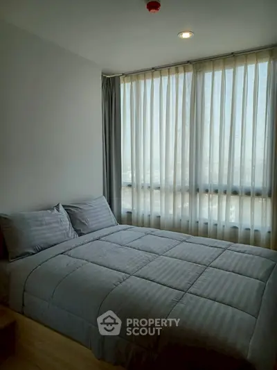 Cozy bedroom with large windows and soft lighting, perfect for relaxation.
