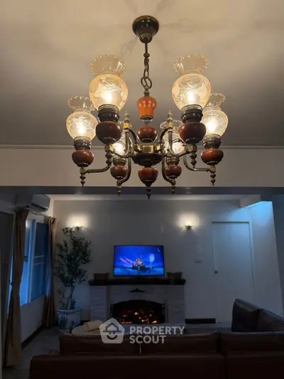 Elegant living room with vintage chandelier and cozy fireplace ambiance.