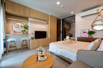 Modern studio apartment with stylish decor and open layout, featuring cozy living area and functional kitchen.