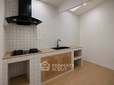 Modern minimalist kitchen with gas stove and wooden cabinets in sleek design.