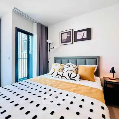 Modern bedroom with stylish decor and balcony access in a contemporary apartment.