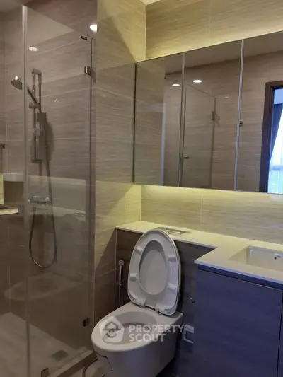 Modern bathroom with glass shower and sleek fixtures in a contemporary apartment.