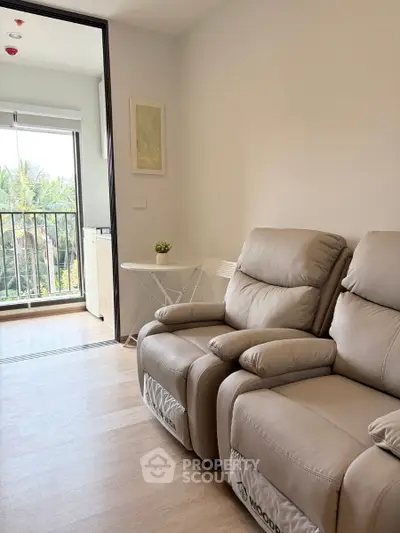 Modern living room with cozy recliners and balcony view in a stylish apartment.