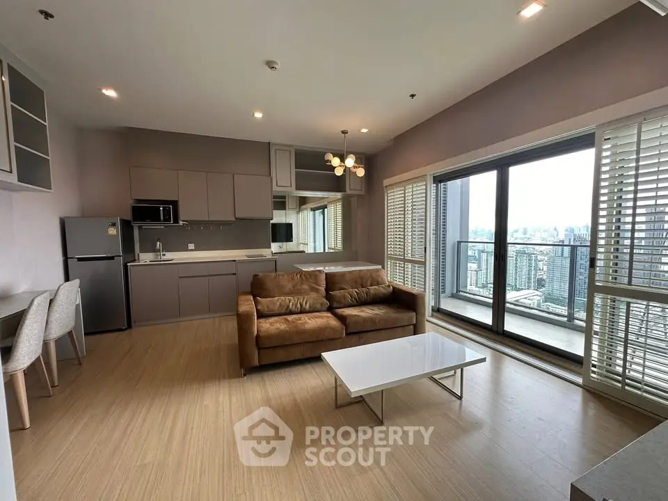 Modern living room with open kitchen and city view balcony in high-rise apartment