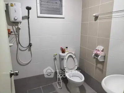 Modern bathroom with shower, toilet, and sink in neutral tones.