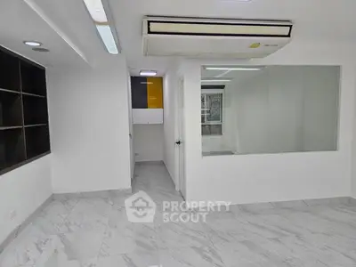 Modern office space with marble flooring and large window for natural light.