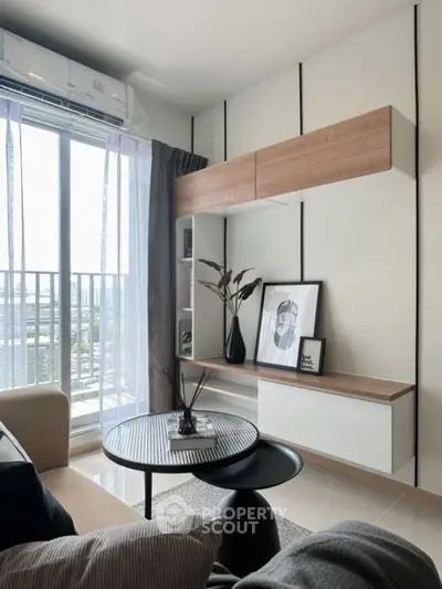 Modern living room with stylish decor and large window offering city view