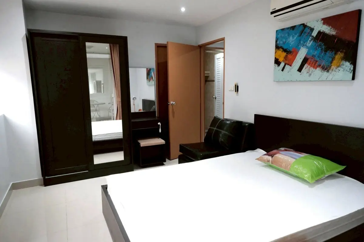 Modern bedroom with sleek furniture and contemporary art, featuring a comfortable bed and spacious wardrobe.