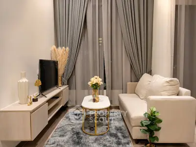 Elegant living room with modern decor, featuring a cozy sofa, stylish coffee table, and sleek entertainment unit.