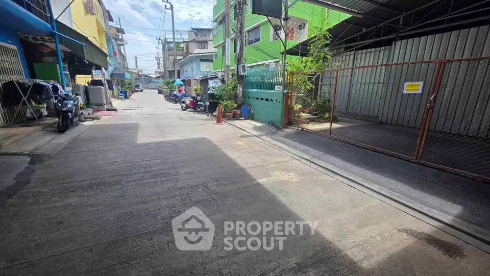 Charming urban street view with colorful buildings and gated entrance, ideal for city living.
