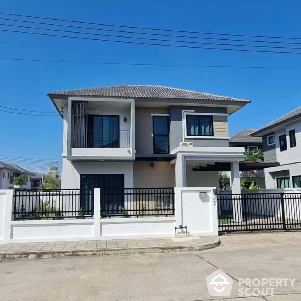 Modern two-story house with sleek design and gated entrance in suburban neighborhood.