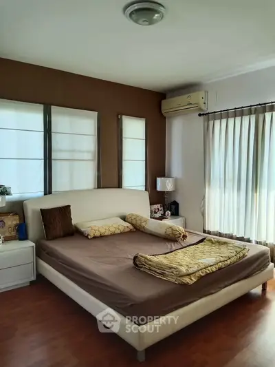 Spacious bedroom with elegant decor and natural light, featuring a comfortable bed and stylish furnishings.
