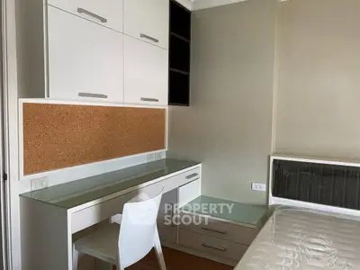 Modern bedroom with built-in desk and storage, featuring sleek design and neutral tones.