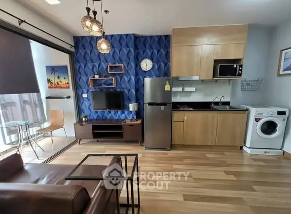 Modern open-plan living room with kitchen, featuring stylish decor and natural light.