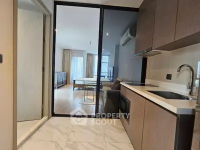 Modern open-layout kitchen with sleek cabinetry and view into spacious living room.