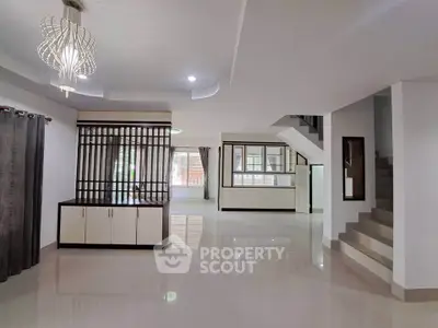 Spacious modern living room with elegant lighting and open layout in a contemporary home.