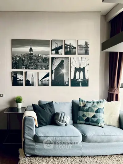 Stylish living room with modern decor and cityscape wall art, featuring a cozy gray sofa and geometric cushions.