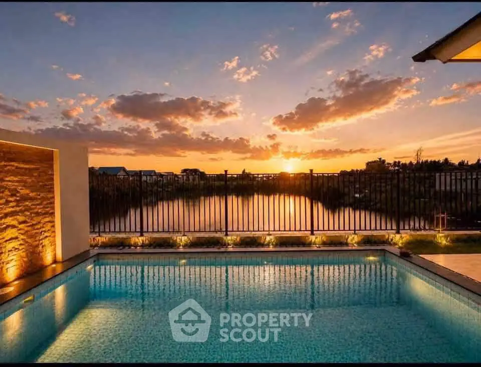 Stunning sunset view over a serene pool with elegant lighting and scenic landscape.